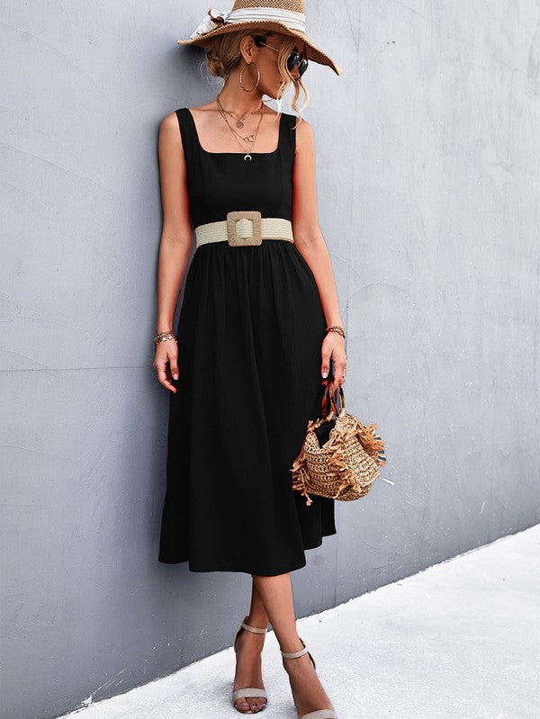 A woman in a Women's Sleeve Less Dress, featuring a vibrant red hue and crafted from 100% polyester, stands against a gray wall. She accessorizes with a wide-brimmed hat, holds a straw handbag, and complements her outfit with beige sandals.