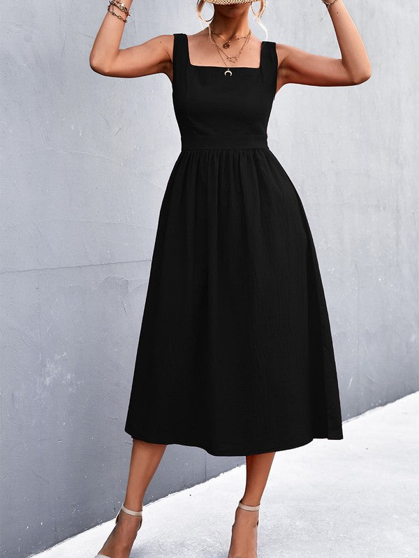 A woman in a Women's Sleeve Less Dress, featuring a vibrant red hue and crafted from 100% polyester, stands against a gray wall. She accessorizes with a wide-brimmed hat, holds a straw handbag, and complements her outfit with beige sandals.