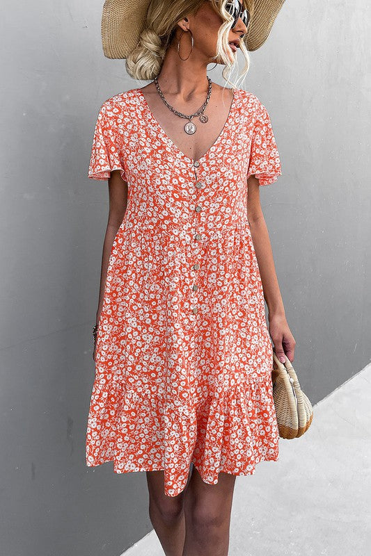 Individual wearing a Floral Short Sleeve V Neck Midi Length Dress stands against a gray wall.