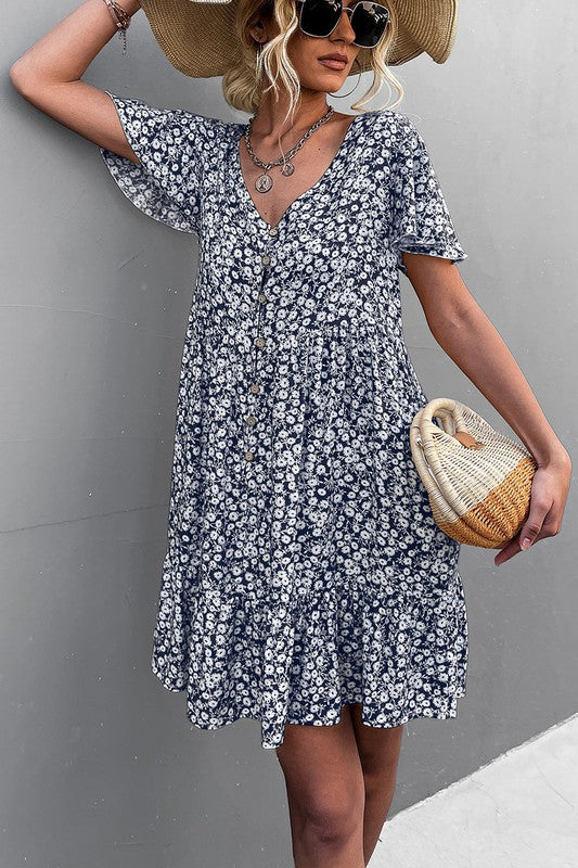 Individual wearing a Floral Short Sleeve V Neck Midi Length Dress stands against a gray wall.