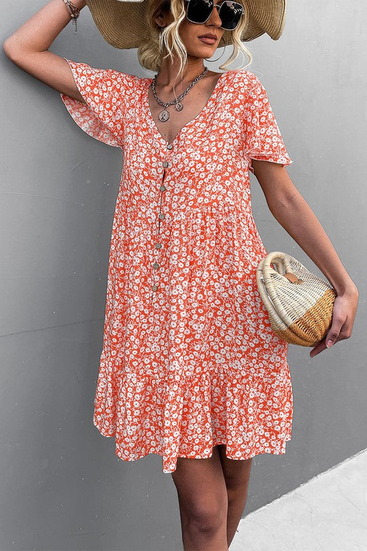 Individual wearing a Floral Short Sleeve V Neck Midi Length Dress stands against a gray wall.