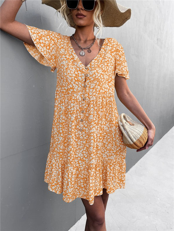 Individual wearing a Floral Short Sleeve V Neck Midi Length Dress stands against a gray wall.