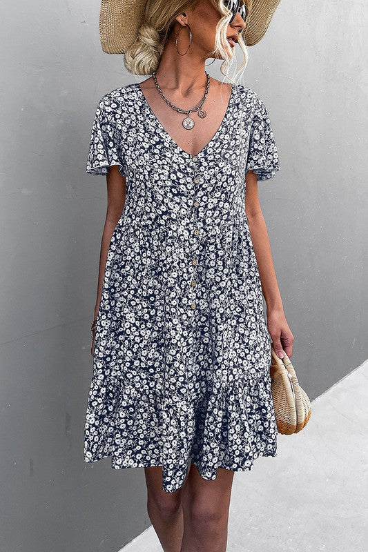 Individual wearing a Floral Short Sleeve V Neck Midi Length Dress stands against a gray wall.