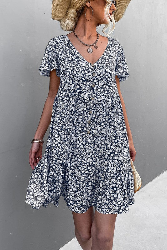 Individual wearing a Floral Short Sleeve V Neck Midi Length Dress stands against a gray wall.