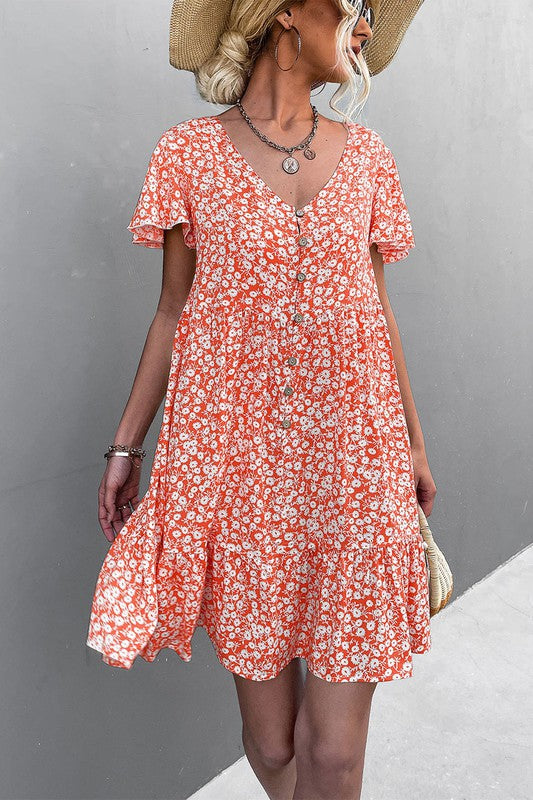 Individual wearing a Floral Short Sleeve V Neck Midi Length Dress stands against a gray wall.