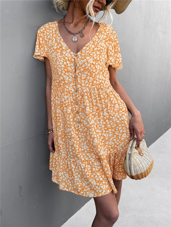 Individual wearing a Floral Short Sleeve V Neck Midi Length Dress stands against a gray wall.