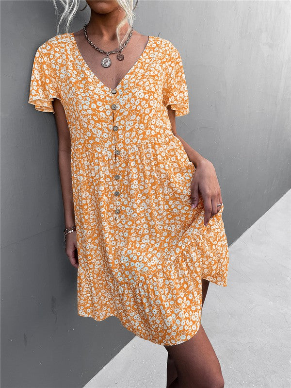 Individual wearing a Floral Short Sleeve V Neck Midi Length Dress stands against a gray wall.