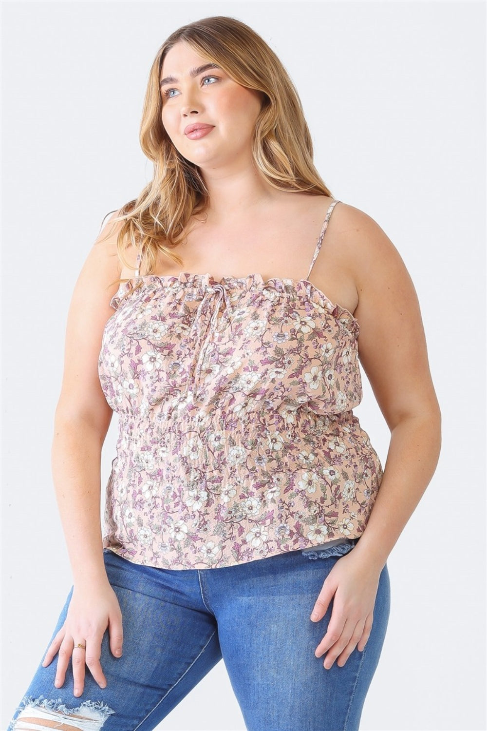 A person with long hair, wearing the Zenobia Plus Size Frill Floral Square Neck Cami and dark jeans, stands with one hand on their hip and the other relaxed by their side.