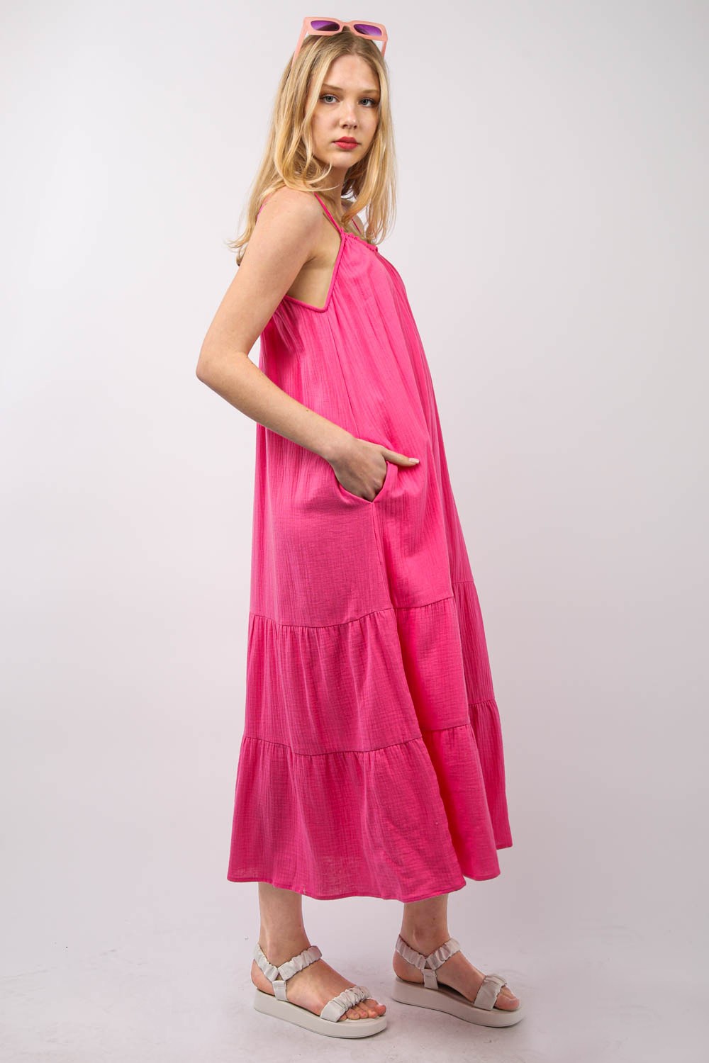 A person with long blonde hair is wearing a bright pink, VERY J Ruffled A-Line Midi Cami Dress and white sandals, standing against a plain background.