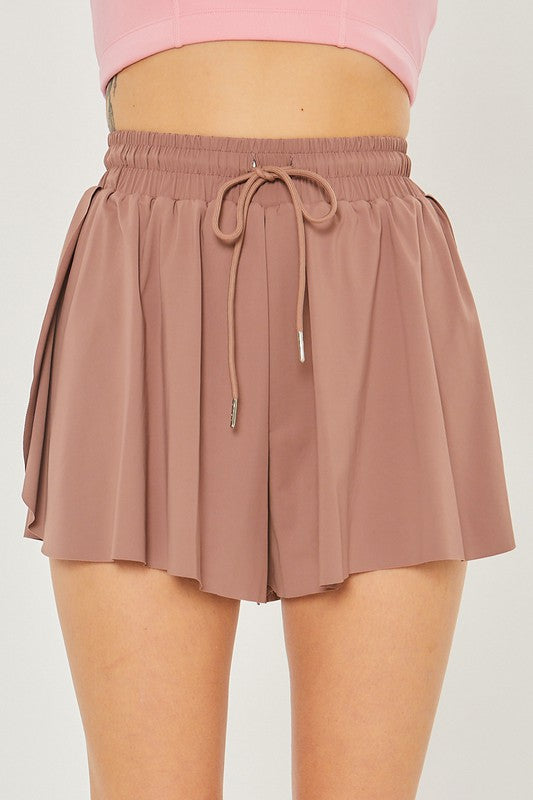 Close-up of a person wearing high-waisted Activewear Two In One Drawstring Shorts in mauve, perfect for activewear.