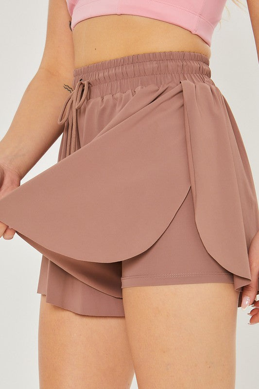 Close-up of a person wearing high-waisted Activewear Two In One Drawstring Shorts in mauve, perfect for activewear.