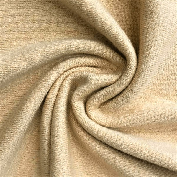 A person wearing a light yellow Open Front Shrug Sweater Knit Cardigan over a white shirt is standing against a white background.