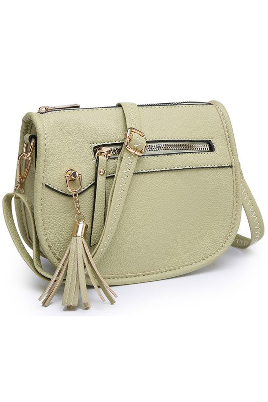 The Fashion Saddle Crossbody Bag in lavender faux vegan leather features a gold zipper, front pocket, tassel detail, and an adjustable shoulder strap.