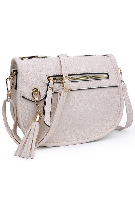 The Fashion Saddle Crossbody Bag in lavender faux vegan leather features a gold zipper, front pocket, tassel detail, and an adjustable shoulder strap.