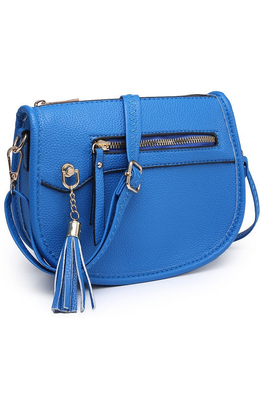 The Fashion Saddle Crossbody Bag in lavender faux vegan leather features a gold zipper, front pocket, tassel detail, and an adjustable shoulder strap.