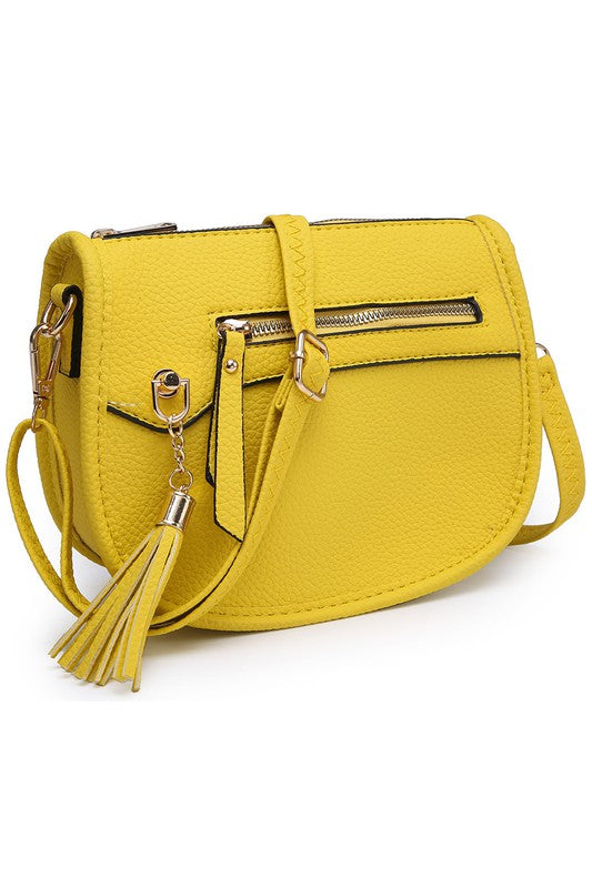 The Fashion Saddle Crossbody Bag in lavender faux vegan leather features a gold zipper, front pocket, tassel detail, and an adjustable shoulder strap.