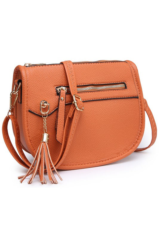 The Fashion Saddle Crossbody Bag in lavender faux vegan leather features a gold zipper, front pocket, tassel detail, and an adjustable shoulder strap.