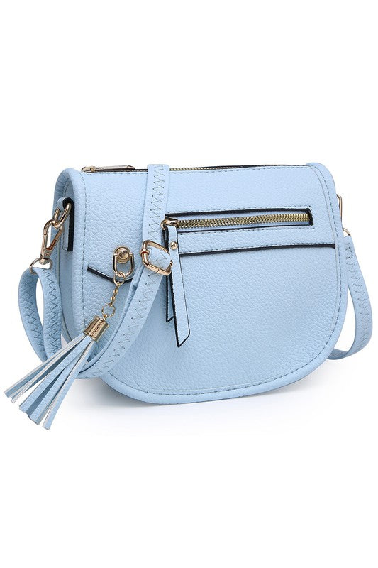 The Fashion Saddle Crossbody Bag in lavender faux vegan leather features a gold zipper, front pocket, tassel detail, and an adjustable shoulder strap.