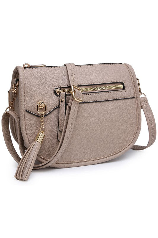 The Fashion Saddle Crossbody Bag in lavender faux vegan leather features a gold zipper, front pocket, tassel detail, and an adjustable shoulder strap.