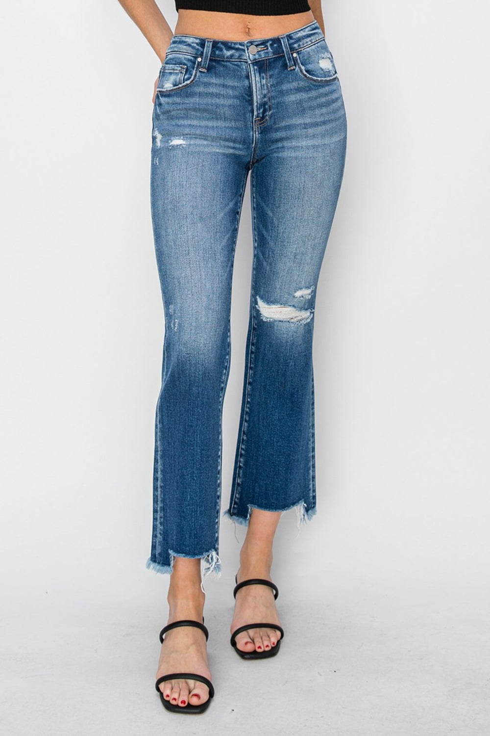 A person wearing RISEN Full Size Frayed Step Hem Ankle Straight Jeans paired with black strappy heels stands against a plain background.