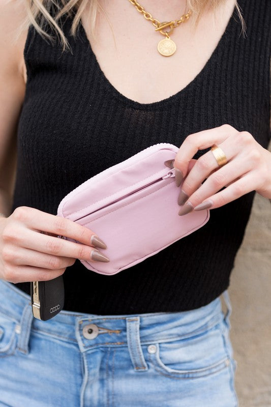 A person holds the Journey Clippable ID Wallet Pouch, featuring a sleek black design crafted from water-resistant nylon, with an ID card cleverly clipped and car keys securely attached.