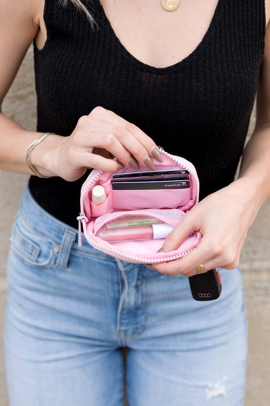 A person holds the Journey Clippable ID Wallet Pouch, featuring a sleek black design crafted from water-resistant nylon, with an ID card cleverly clipped and car keys securely attached.