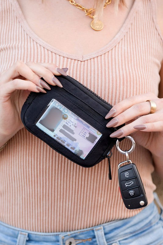 A person holds the Journey Clippable ID Wallet Pouch, featuring a sleek black design crafted from water-resistant nylon, with an ID card cleverly clipped and car keys securely attached.