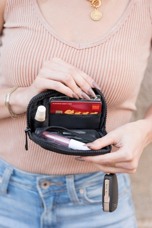 A person holds the Journey Clippable ID Wallet Pouch, featuring a sleek black design crafted from water-resistant nylon, with an ID card cleverly clipped and car keys securely attached.