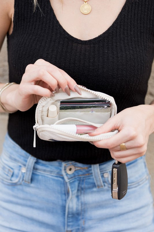 A person holds the Journey Clippable ID Wallet Pouch, featuring a sleek black design crafted from water-resistant nylon, with an ID card cleverly clipped and car keys securely attached.