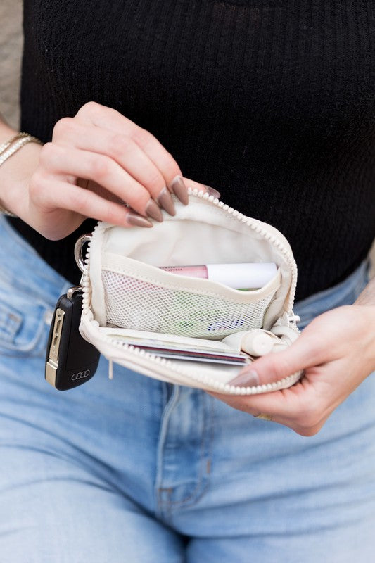 A person holds the Journey Clippable ID Wallet Pouch, featuring a sleek black design crafted from water-resistant nylon, with an ID card cleverly clipped and car keys securely attached.