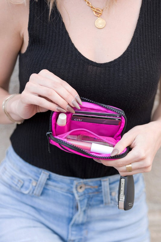 A person holds the Journey Clippable ID Wallet Pouch, featuring a sleek black design crafted from water-resistant nylon, with an ID card cleverly clipped and car keys securely attached.