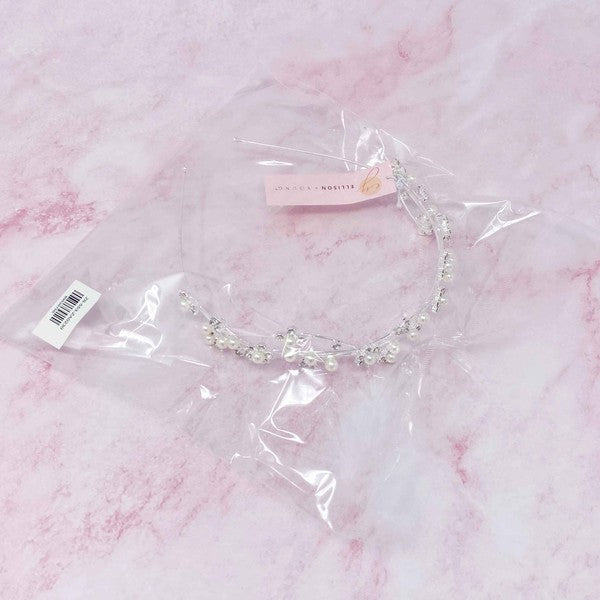 Artful Snow Flower Headband with pearls and crystals on a black marble background.