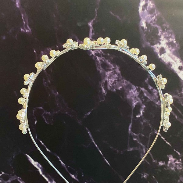 Artful Snow Flower Headband with pearls and crystals on a black marble background.