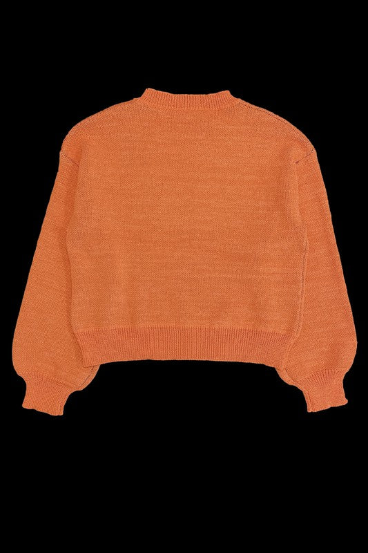 Pumpkin Halloween Sweater featuring an orange design with a winky jack-o'-lantern face on the front, set against a black background.