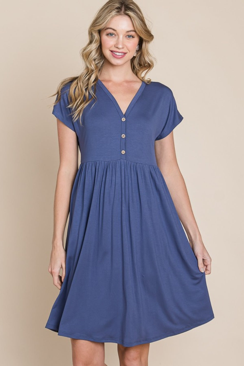 The BOMBOM V-Neck Short Sleeve Dress, crafted from soft rayon spandex fabric, showcases a blue hue with short sleeves and distinctive button accents.