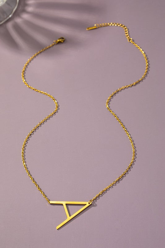 The Large Stainless Steel Initial Pendant Necklace features gold necklaces with prominent, capital letters "A," "B," and "C" set against a vibrant purple background, forming a stunning collection of initial pendants. Crafted from high-quality stainless steel, these pieces offer both durability and style.