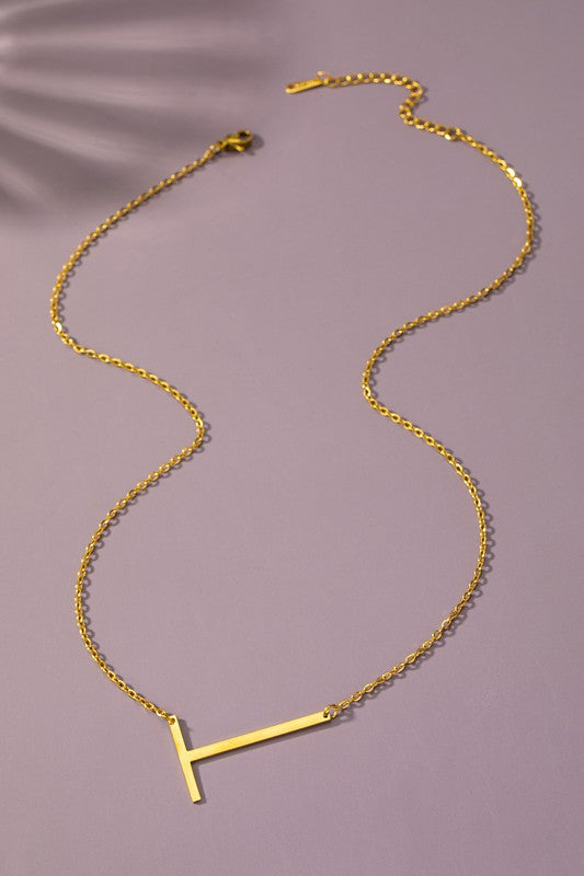 The Large Stainless Steel Initial Pendant Necklace features gold necklaces with prominent, capital letters "A," "B," and "C" set against a vibrant purple background, forming a stunning collection of initial pendants. Crafted from high-quality stainless steel, these pieces offer both durability and style.