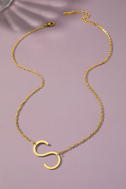 The Large Stainless Steel Initial Pendant Necklace features gold necklaces with prominent, capital letters "A," "B," and "C" set against a vibrant purple background, forming a stunning collection of initial pendants. Crafted from high-quality stainless steel, these pieces offer both durability and style.