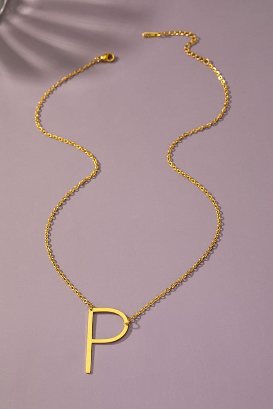 The Large Stainless Steel Initial Pendant Necklace features gold necklaces with prominent, capital letters "A," "B," and "C" set against a vibrant purple background, forming a stunning collection of initial pendants. Crafted from high-quality stainless steel, these pieces offer both durability and style.