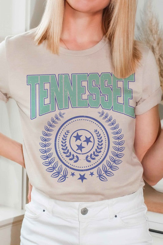 A person wearing a light gray "TENNESSEE GRAPHIC TEE" with a unique design and light plaid shorts.