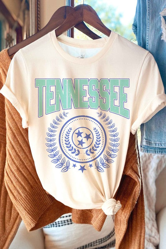 A person wearing a light gray "TENNESSEE GRAPHIC TEE" with a unique design and light plaid shorts.