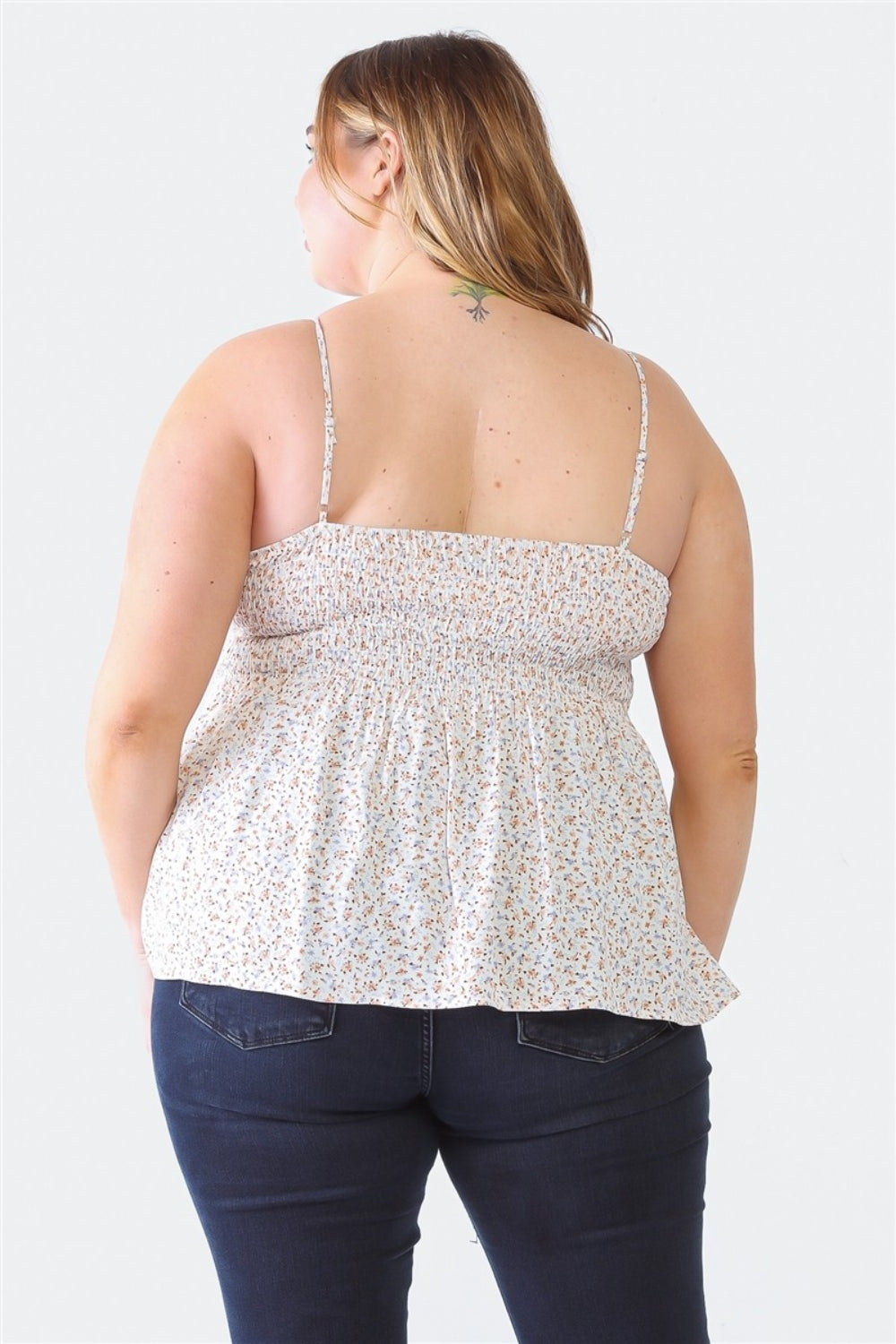 A woman stands facing the camera wearing a Zenobia Plus Size Frill Smocked Floral Sweetheart Neck Cami with dark jeans, against a plain background.