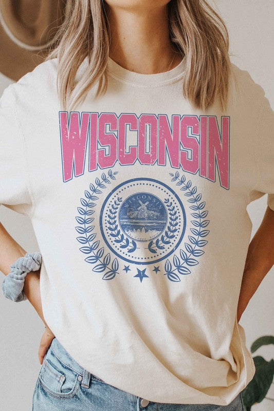 A person wearing a 100% cotton WISCONSIN GRAPHIC TEE, featuring the word "Wisconsin" in pink letters and a blue emblem with laurel wreaths underneath, designed for unisex sizing to fit everyone.