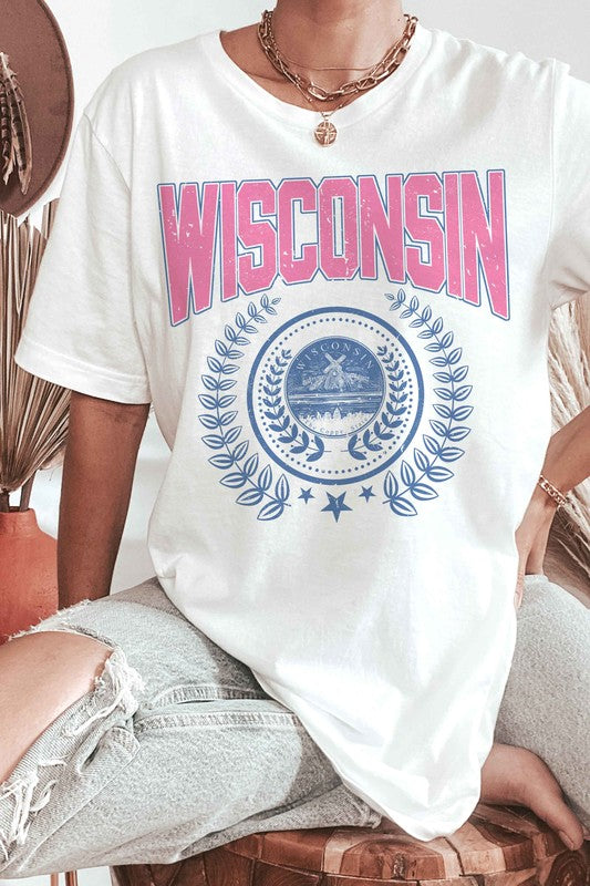 A person wearing a 100% cotton WISCONSIN GRAPHIC TEE, featuring the word "Wisconsin" in pink letters and a blue emblem with laurel wreaths underneath, designed for unisex sizing to fit everyone.