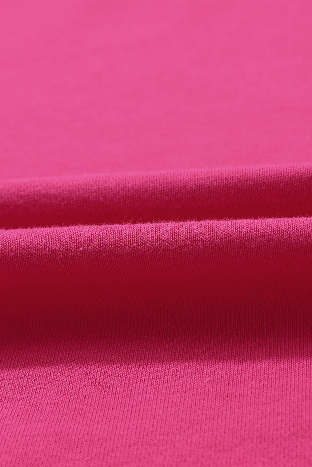 A person with wavy hair is standing with one hand on their hip, wearing a Strawberry Pink MERRY Christmas Tree Sequin Patchwork Sweatshirt and blue jeans. The person is facing away from the camera.