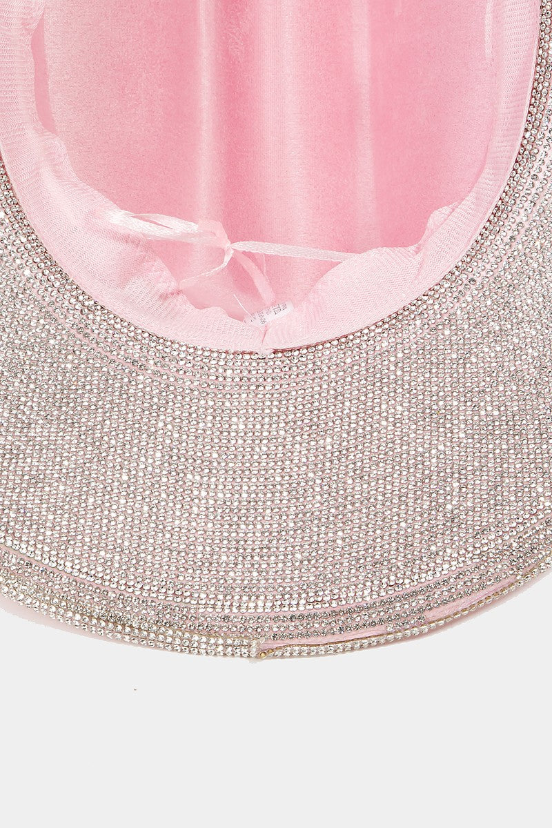 A woman with blond hair is wearing the Fame Pave Rhinestone Trim Faux Suede Hat in pink and a black top, looking at the camera against a plain white background.