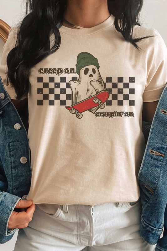 Wearing the "CREEP ON CREEPIN' ON" graphic tee, which is a 100% cotton white t-shirt featuring a ghost on a skateboard with the text "creep on creepin' on," the person holds an iced coffee.