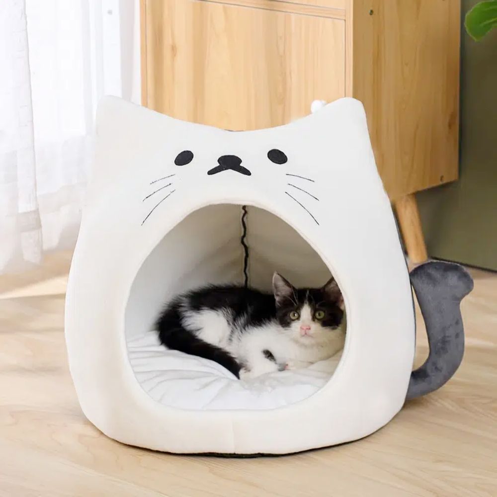 An Adorable Cat Shape Pet House nestled in a cozy pet house designed like a cat shape bed, enjoying the soft spot.