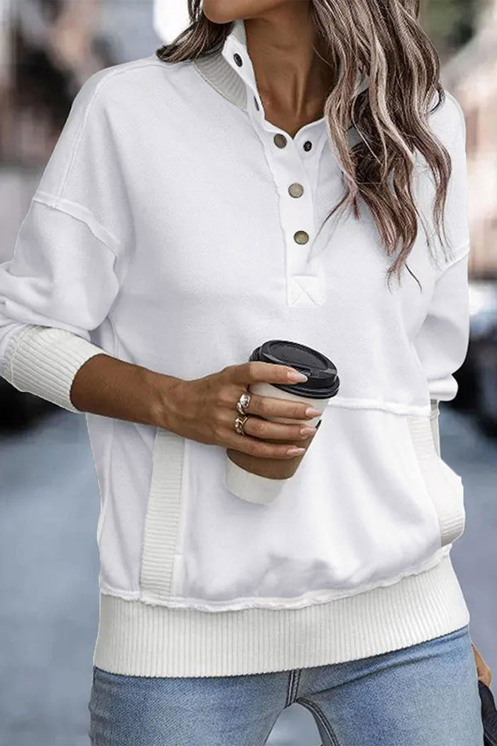 A woman with long hair wearing a White Ribbed Hem Snap Button Neckline Sweatshirt with Pocket is seen from behind, standing against a plain background, embodying a casual look.