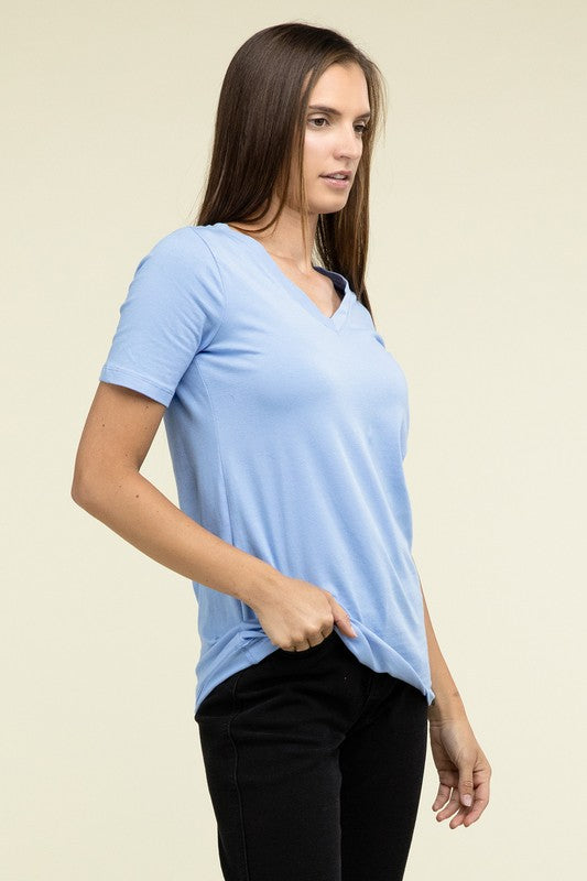 A person with long hair is standing and wearing a light blue Cotton V-Neck Short Sleeve T-Shirt and black pants.